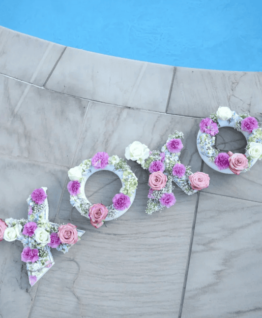 floating 3D floral letters spelling xoxo in Bali villa pool